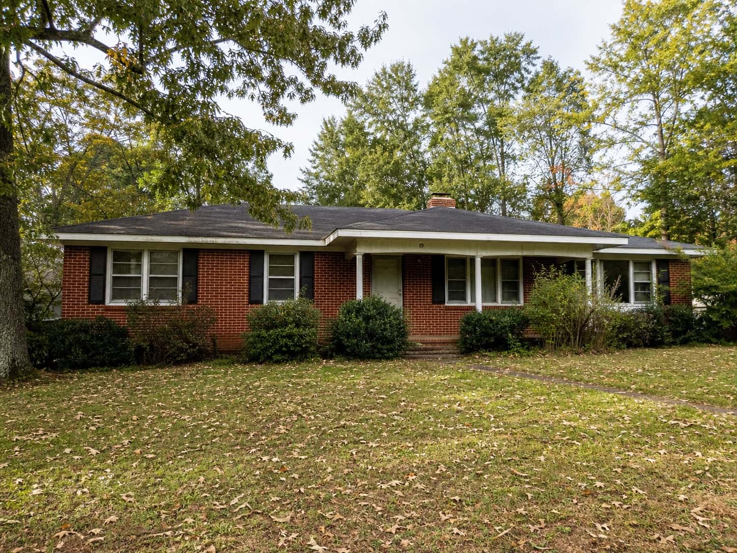 Older red-brick Georgia home beneath mature trees.